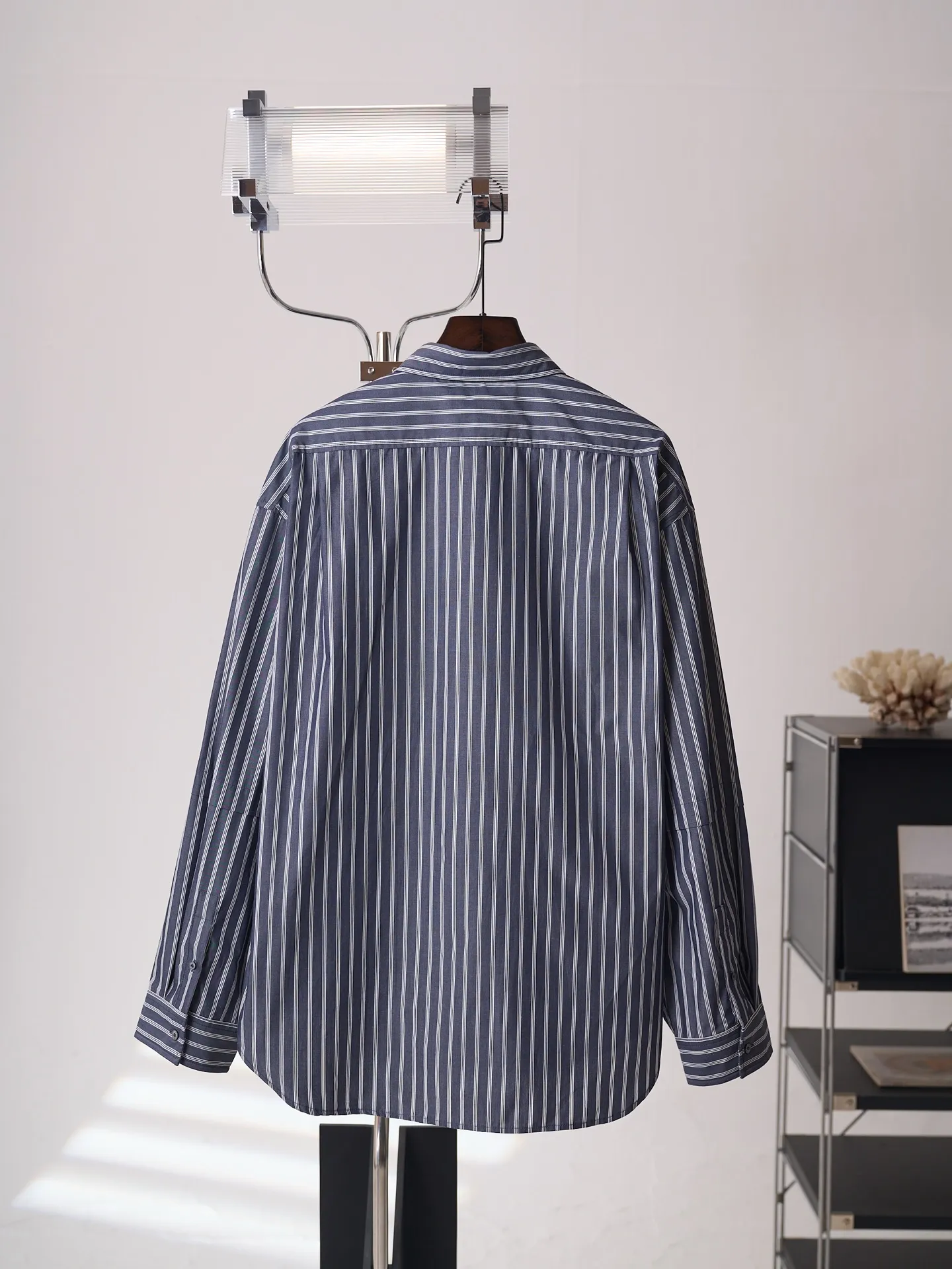 [Real auction] Acne Studios logo double-sleeved striped long-sleeved shirt [In Stock] 44 46 48 50 Customized matte woven combed poplin, crisp and stylish, comfortable and close to the skin, misty charcoal blue interwoven with pure white vertical stripes, between the rising and falling lines, revealing the cool and relaxed style of Scandinavia. Cleverly created layered double-sleeved deconstructed tailoring, breaking the inherent paradigm of traditional shirts, giving the body staggered three-dimensional layers. The iconic stripes of the season are laid out vertically. Rhythm runs through the entire garment. The left chest pocket is embellished with the Acne Studios logo. The brand context is engraved in the square dimensions. The side seams are equipped with wide welt pockets. Integrating styling aesthetics and practical functions. Adhering to the high-end aesthetics of minimalism. Pioneer ingenuity returns to daily life. It interprets the Nordic ready-to-wear attitude of symbiosis of relaxation and sophistication. Infrared positioning cutting machine uses infrared emitters and infrared receivers to achieve precise positioning of materials. The accuracy can reach the micron level. So as to meet the effect of high-precision cutting of plaid alignment. Manual infrared line drawing pockets are assisted by infrared technology to achieve precise positioning and marking of pocket positions, which retains the fineness and flexibility of hand sewing. It adopts side-turning embedded stitching technology to provide high-quality stitching results. Smooth and tidy. The fabrics have been sand washed and have a better hand feel. Not easy to deform, not easy to shrink, not easy to fade, and maintain long-term beauty and loose fit.